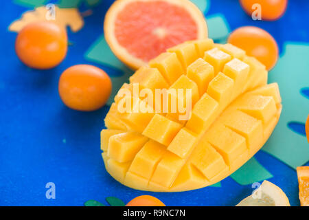 Exotic fruits close-up. Mango, oranges, kumquat and other tropical fruits vibrant blue background with copy space. Stock Photo