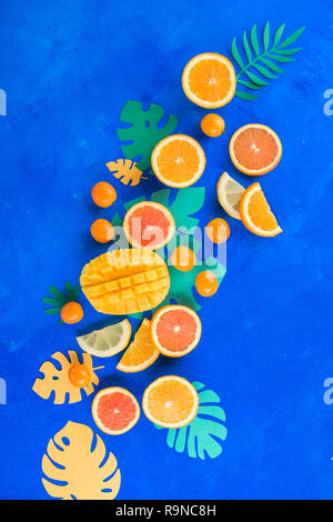 Citrus fruits, mango, oranges, kumquat, and other tropical fruits vibrant blue background with copy space. Exotic fruits close-up. Stock Photo