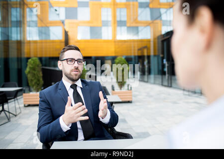Adult businessman on terrace talking to colleague Stock Photo