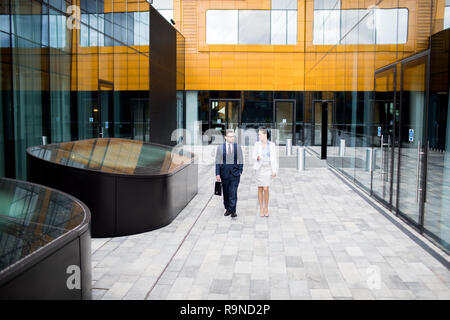 Talking coworkers walking on building terrace Stock Photo