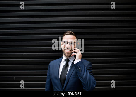 Laughing business man with smartphone Stock Photo