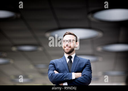 Smiling man crossing hands Stock Photo