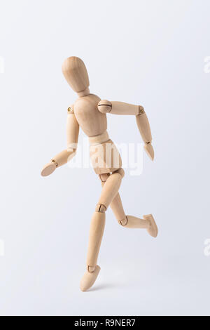Business and design concept - running wooden mannequin isolated on white background Stock Photo