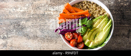 Vegan Buddha bowl with fresh raw vegetables and quinoa on wooden table. Panoramic view. Copyspace Stock Photo