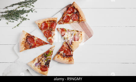 Banner 16 x 9 size image for web. Hot Italian pizza with melting tomato,pepperoni and cheese on a white rustic wooden table. Stock Photo