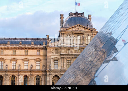 The Museum of Louvre during a cloudy day. The building is reflecting on the surface of a pyramid. Close up shot. Paris, France Stock Photo