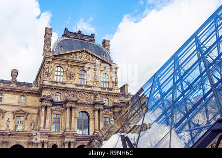 The Museum of Louvre during a cloudy day. The building is reflecting on the surface of a pyramid. Close up shot Stock Photo