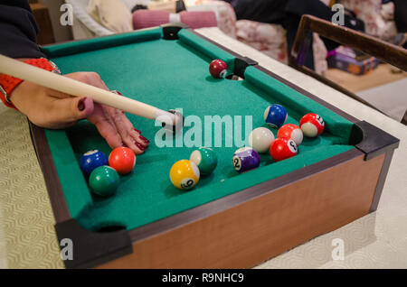 A game of pool on a small, tabletop pool table. Stock Photo