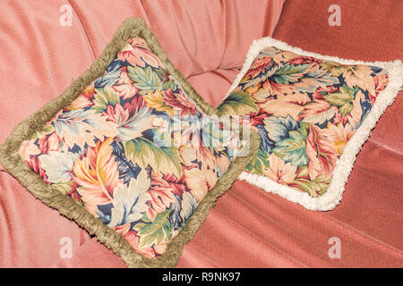Pillows with floral pattern on pink sofa Stock Photo