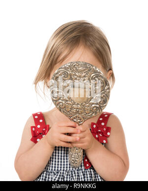 Cute young caucasian girl looking at herself in mirror Stock Photo