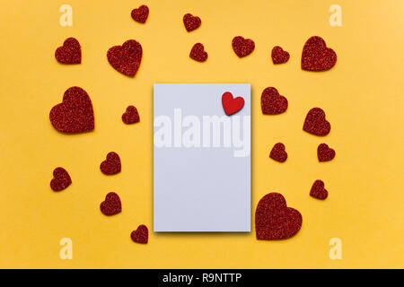 Blank sheet with red heart for text or write. Near many red hearts. Concept for Valentine's Day or Women's Day or Mother's Day. Stock Photo