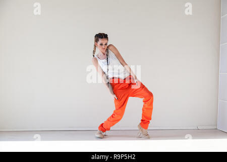 beautiful fashionable woman with braids dancing work overalls