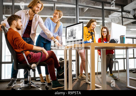 Group of a young coworkers working together on architectural project with computers in the modern office Stock Photo