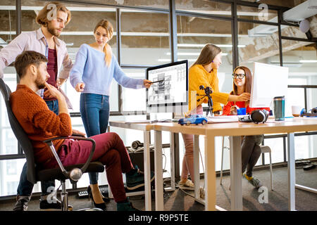 Group of a young coworkers working together on architectural project with computers in the modern office Stock Photo