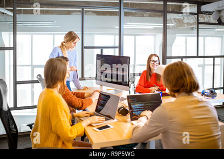 Team of a young programmers dressed casually working on computer code sitting in the modern office interior Stock Photo