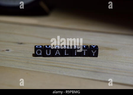 Quality written on wooden blocks. Education and business concept on wooden background Stock Photo