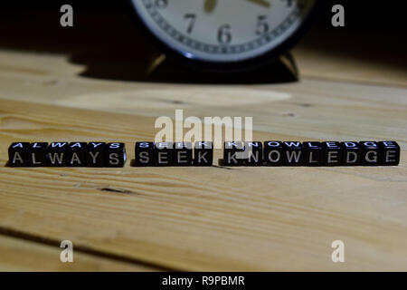 Always seek knowledge written on wooden blocks. Education and business concept on wooden background Stock Photo