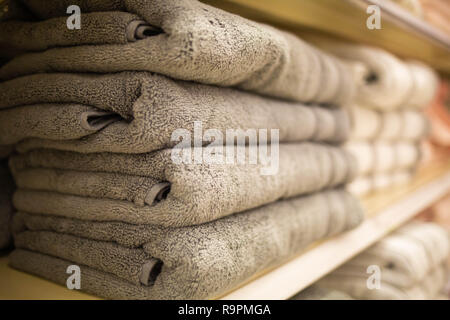 Folded grey towels on the shelf clean after loundry Stock Photo