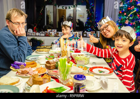 A family sit at a dining table laid out with salad for a Christmas tea, Stock Photo