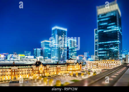 Asia Business concept for real estate and corporate construction - panoramic city view and tokyo station under neon night in tokyo, Japan with tilt sh Stock Photo