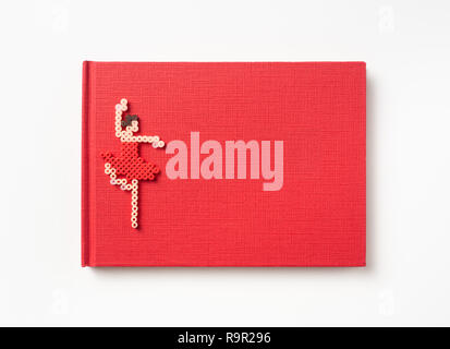 Design concept - Top view of red hardcover notebook and dance girl doll isolated on background for mockup Stock Photo