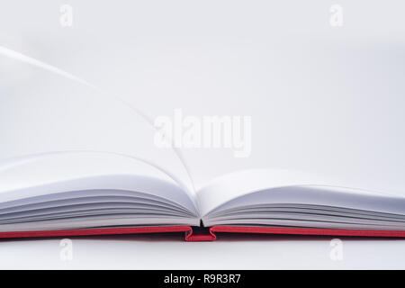 Design concept - Perspective view red hardcover notebook with open & flip curl rolled page isolated on background for mockup. Not 3D render Stock Photo