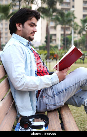 Man is sitting on the bench and looking diary. Stock Photo