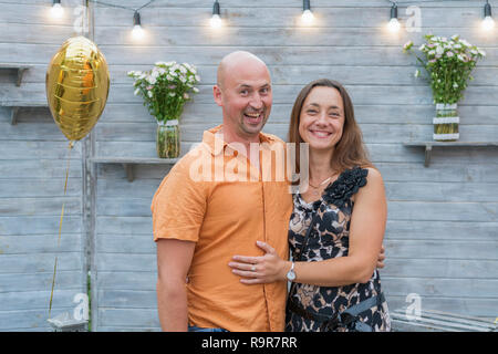 Funny mature couple standing on grey background. Middle-aged couple standing on grey background. Couple standing on grey background Stock Photo