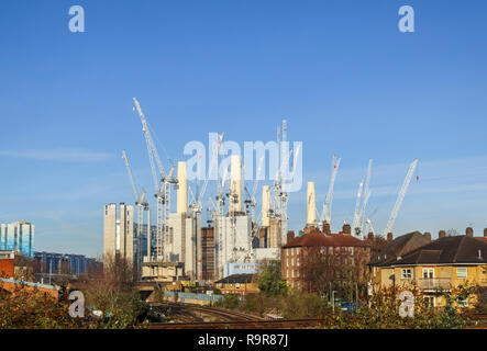 White tower cranes surround the iconic decommissioned Battersea Power Station being redeveloped for mixed uses and high class luxury apartments Stock Photo