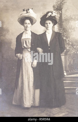 RUSSIA - CIRCA 1905-1910: Full body shot of two young women in studio, Vintage Carte de Viste Edwardian era photo Stock Photo