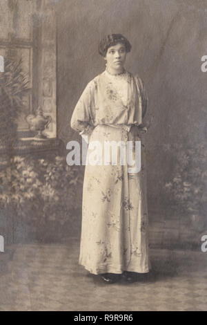 RUSSIA - CIRCA 1905-1910: Full body shot of young woman in studio, Vintage Carte de Viste Edwardian era photo Stock Photo