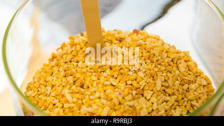 hazelnut sprinkles in a large glass jar for sprinkling on ice cream or other desserts Stock Photo