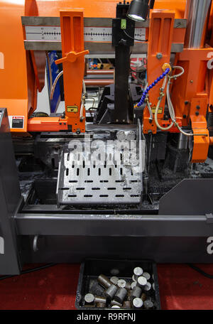 Band saw machine cutting metal work piece with coolant Stock Photo