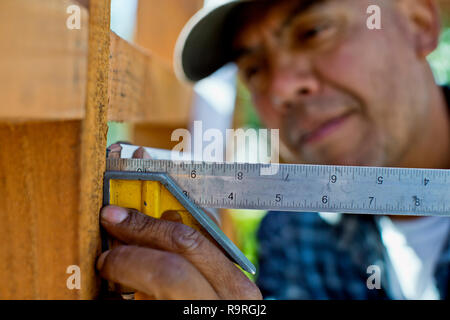 Builder putting down a hammer on a building site. Stock Photo