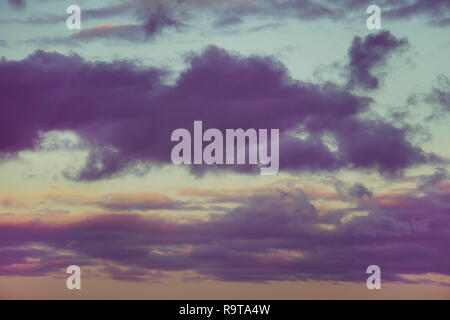 Dramatic sunset with clouds of dark tones in the blue sky. Natural composition. dark toned sky. evening light. dramatic scenery. Stock Photo