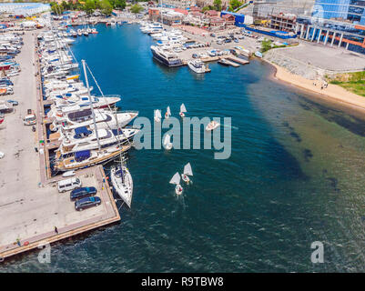 Aerial drone photo of young teenagers on small sailing boats competing in the regatta at mediterranean emerald sea Stock Photo