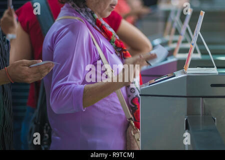 Many Tourists at pedestrian access control flap barriers. Selective focus on Flap Gate Barrier. Stock Photo