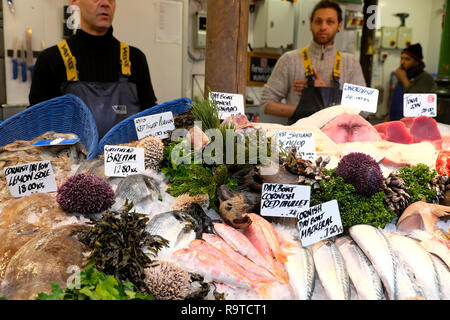 Fishmongers selling various fresh fish on Borough Market seafood stall in November Southwark South London England UK  KATHY DEWITT Stock Photo