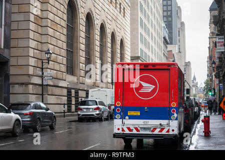 MONTREAL, CANADA - NOVEMBER 6, 2018: Canada Post logo on one of their delivery trucks in a street of Montreal, Quebec. Also known as Postes Canada, it Stock Photo