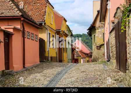 Stone paved old streets with colorful houses in Sighisoara, Romania. Historic center of the city is a UNESCO World Heritage Site.