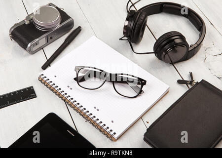 workplace with tablet pc, notepads, camera and pen Stock Photo