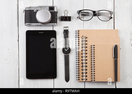 workplace with tablet pc, notepads, camera, watch and pen Stock Photo