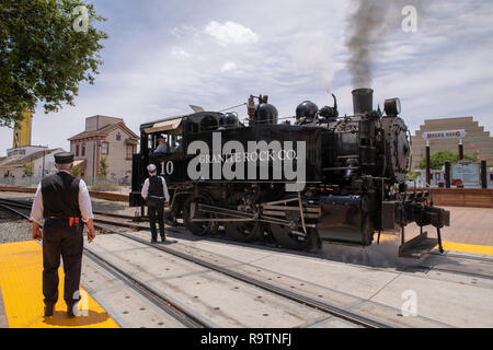 Granite Rock Co locomotive under steam at the Railway museum in Sacramento California. Two smartly dressed officials with backs to the camera. Stock Photo