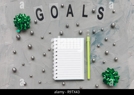 GOALS word, notepad and green pen on a gray and blue background. Top view, flat lay, mockup. Winter, Christmas to do list and New Year resolutions con Stock Photo