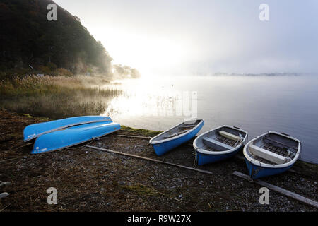 Small blue boats beside a Lake, with Mount Fuji behind, Central Honshu, Japan Stock Photo