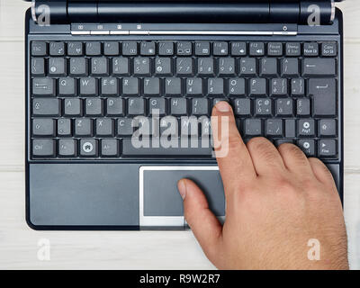Male hand typing on laptop keyboard top view Stock Photo