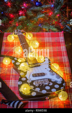 Seasonal holiday musical instrument ukulele with Christmas tree background Stock Photo