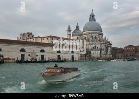 Venetian water taxi in front of the Basilica of Santa Maria della Salute (Basilica di Santa Maria della Salute) on the Grand Canal (Canal Grande) in Venice, Italy. Stock Photo