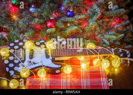 Seasonal holiday musical instrument ukulele with Christmas tree background Stock Photo