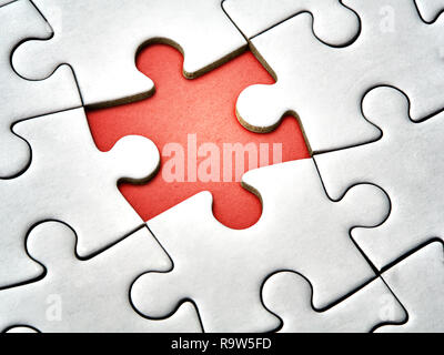 Closeup missing last piece of white jigsaw puzzle Stock Photo